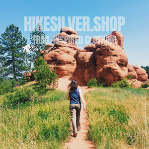 Woman hiking toward red rock formations in Colorado trail.Hiking clothes for women Colorado